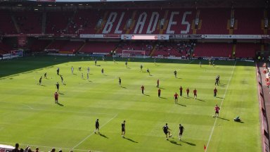 Vindingrijke fan Sheffield United kijkt wedstrijd vanuit geparkeerde bus